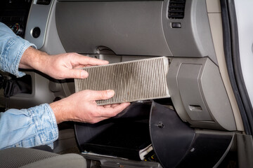 Mechanic for cars inspects the cabin air filter in a pickup