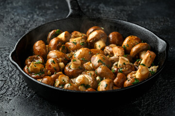 Fried mushrooms with onion and garlic in iron cast pan