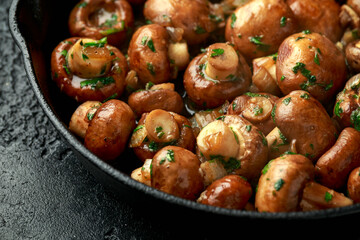Fried mushrooms with onion and garlic in iron cast pan