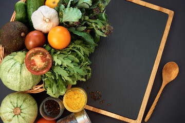 Vegetables dark background with copy space. Healthy meal. Menu, price background. Vegetables on black chalkboard.