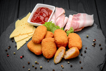 fast food chicken nuggets with ketchup, against a dark background