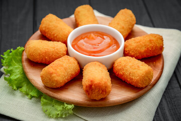 cheese nuggets with fruit sauce, on a wooden plate