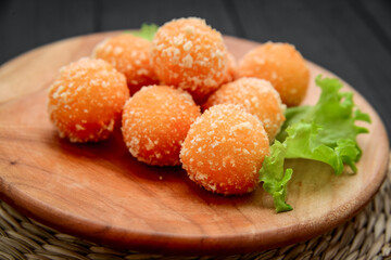 fried cheese ball on a wooden plate