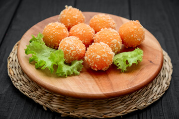 fried cheese ball on a wooden plate