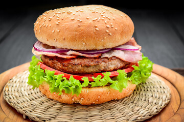 Bacon burger with beef cutlet on wooden background