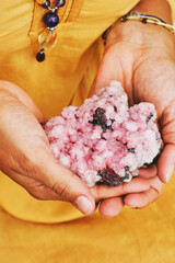 Close up image of pink amethyst crystal holding by a woman