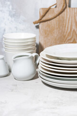 clean tableware, cutlery and kitchen utensils on white background, vertical closeup