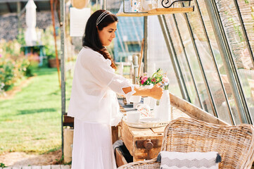 Woman drinking tea and relaxing in geenhouse