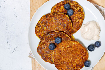 homemade pancakes with blueberries and yogurt on white background, top view