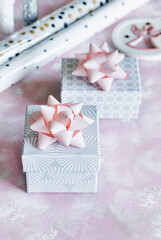 Christmas and New Year holiday background or greeting card. Gray white gift boxes with pink bows. 