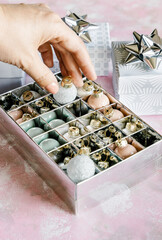 Christmas and New Year holiday background or greeting card. Mini ornaments and gray white gift boxes with silver bows. 