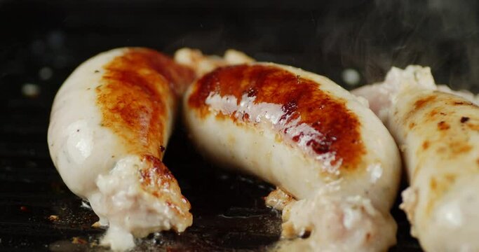 Fried sausage with hot staem in a frying pan. 