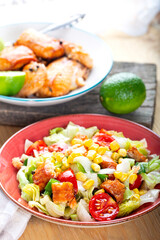 Fresh salad with grilled salmon on table.