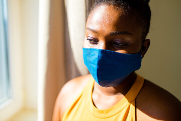 african american woman feeling alone at her home looking to outdoors from her apartment balcony