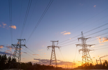 High-voltage power lines at sunset or sunrise. High voltage electric transmission tower