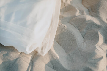 CloseUp of beautiful white wedding bride dess on the beach background on the soft sunset light. Location Germany, Sankt Peter-Ording.