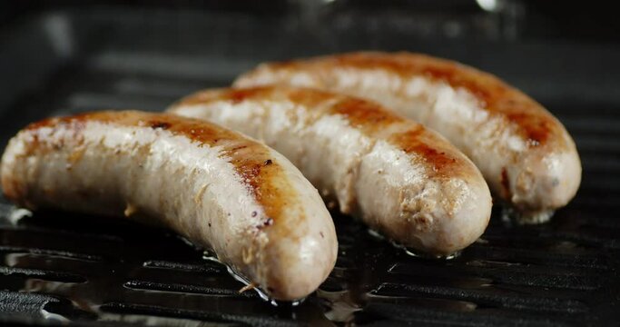 Fried sausage with hot staem in a frying pan. 