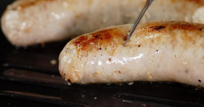 Fried sausage is pierced with a fork. 