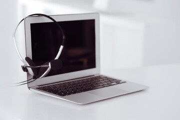 Call center and communication support, customer service help desk. VOIP headset on laptop computer