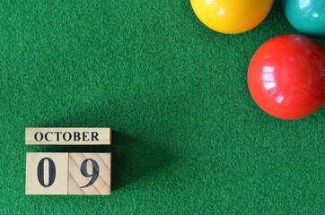 October 9, number cube with balls on snooker table, sport background.