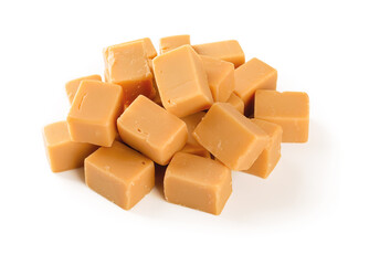 Pile of caramel vanilla fudge isolated on white background. Fresh tasty candies made of milk and sugar. Square pieces of delicious chewy soft sweets. Full depth of field.