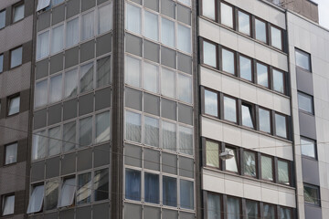 Close-up of the modern concrete glass facade of a business skyscraper with reflections in the windows