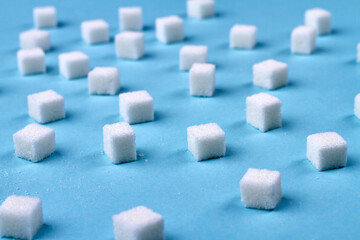 Sugar on the blue background. Cubes of sugar is cause of diabetes.