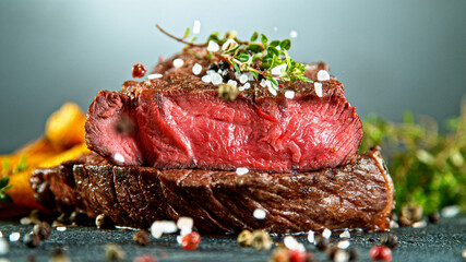 Close-up of tasty beef steak on black stone table