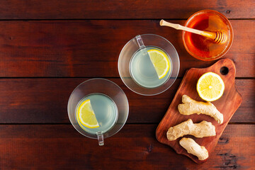 Ginger tea with lemon. Two cups of ginger tea with lemon and honey on wooden background. Top view