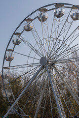 Fototapeta premium Ferris wheel with seats. The blue sky is in the background.