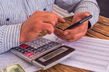 Businessman using calculator to calculate numbers