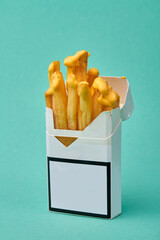 Pack of cigarettes with mustard sauce topping. Advertisement against unhealthy fast food. Isolated...