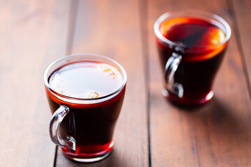 Mulled wine on wooden background. Winter drink traditional for the Christmas holidays. Two glasses of Christmas mulled wine with oranges