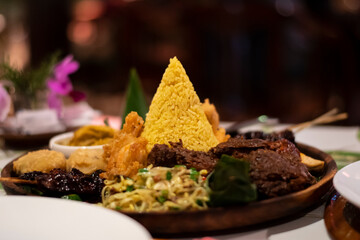 Freshly cooked dinner platter with decoration of spicy meat and green vegetables and sauce in a restaurant in Bali