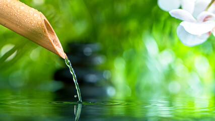 Bamboo with water stream over the water , relaxation with water ripple drops concept