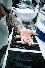Selective focus of barber spraying water on comb near equipment on table 