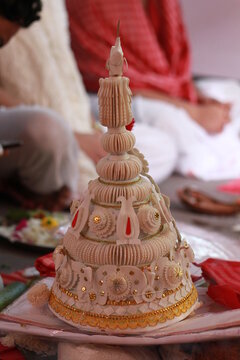A "Topor" is a type of conical headgear traditionally worn by grooms as part of the Bengali Hindu wedding ceremony.