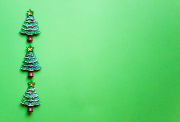 Top view Christmas trees on green background. Free copy space. Concept of decoration, greeting cards.