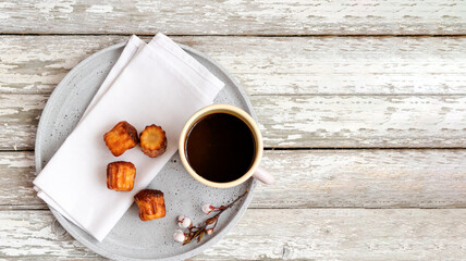 Top view to some pastry and cup of black coffee on plate and wooden old table. Copy space.
