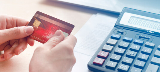 Concept of online payments, purchase, payment of bills. Bank card in hands above the table,banner