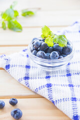  Juicy and fresh blueberries with green leaves. Creative atmospheric decoration