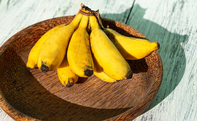 Banany na jasnym tle w świetle dziennym. © insomniafoto