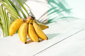Banany na jasnym tle w świetle dziennym. © insomniafoto