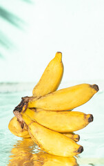 Banany na jasnym tle w świetle dziennym. © insomniafoto