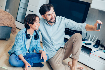 Fototapeta premium Happy man taking photos to catch pleasant moments with son