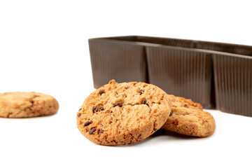 Cookies with chocolate pieces with plastic containers in the background isolated on a white background