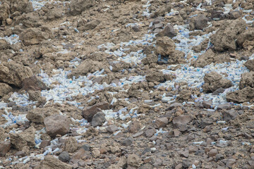 Lots of plastic bottles tossed among the stones in the desert