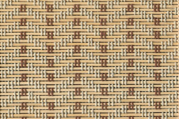 Mat made from straw with a pattern of threads. Straw background with a pattern, folk pattern.