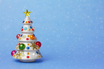 Fototapeta na wymiar beautiful Christmas tree decorated with beads on a blue snow background with space for text 