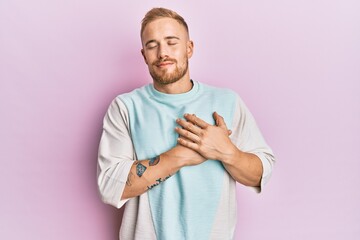 Young caucasian man wearing casual clothes smiling with hands on chest with closed eyes and grateful gesture on face. health concept.